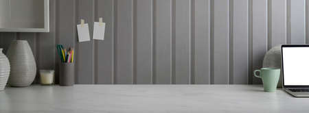 Close up view of modern home office with mock-up laptop, stationery decorations and copy space on...