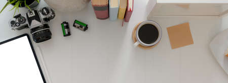 Overhead shot of home office desk with copy space, books, camera, coffee cup and decorations on white desk  の写真素材