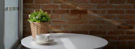 Close up view of coffee table with coffee cup, decoration and copy space on white circle table in vintage coffee shop の写真素材