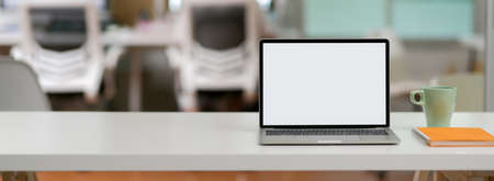 Close up view of simple office desk with blank screen laptop and copy space on white desk の写真素材