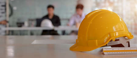 Close up view of engineer worktable with safety helmet, copy space and measuring tool on white desk...