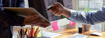Cropped shot of businesspeople consulting on their project with digital tablet at office room