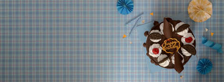 Top view of blue scott background with copy space , cake, candles and decorationsの写真素材