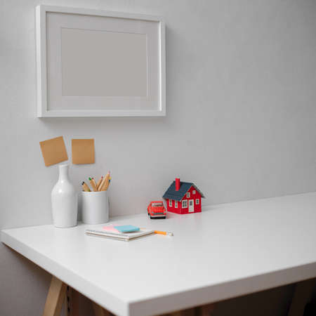 Close up view of minimal worktable with stationery, notepad, decorations and copy space on white...