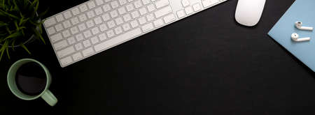 Top view of black and white worktable with computer device, notebook, coffee cup , decoration and copy spaceの写真素材