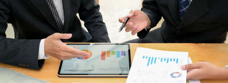 Close up view of business partner discussing on their collaboration with document cart on digital...