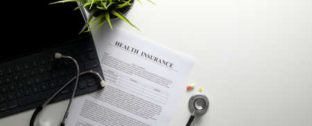 Life planning concept with health insurance form, stethoscope, digital tablets and medicine on white...