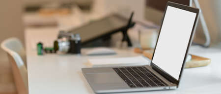 Side view of female graphic designer working on drawing tablet with stylus pen in office room 