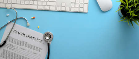 Life planning concept with health insurance form, stethoscope, computer device and pills on creative worktable in top viewの写真素材