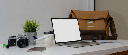 Travel preparation concept with mock-up laptop, camera, passport and travel accessories on white worktableの写真素材