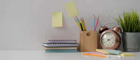 Close up view of home office desk with diary notebooks, stationery, decorations and copy space on...