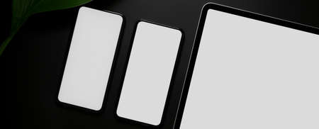 Top view of blank screen smartphones and digital tablet on dark modern backgroundの写真素材