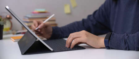 Side view of female employee working on digital tablet with stylus pen on office desk