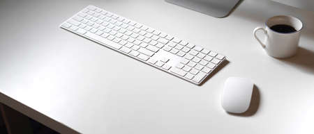 Cropped shot of minimal office desk with computer devices, coffee cup and copy spaceの写真素材