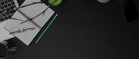 Top view of dark modern workspace with open blank schedule book, glasses, laptop, decorations and...