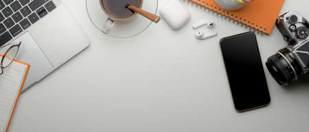 Top view of modern office desk with copy space, smartphone, laptop, coffee cup and suppliesの写真素材