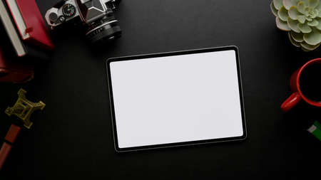Top view of feminine stylish worktable with mock-up tablet, camera, coffee mug,  cosmetics and...