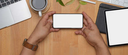 Top view of designer office desk with computer, painting tool, books and decorations on wooden tableの写真素材