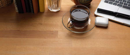 Top view of designer office desk with computer, painting tool, books and decorations on wooden tableの写真素材