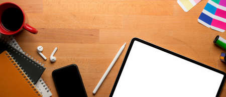 Top view of modern worktable with mock-up tablet, laptop, copy space, camera and stationery on...