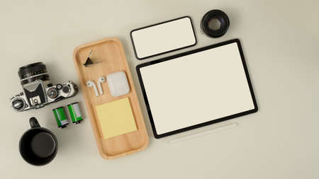Top view of photographer worktable with mock up tablet, smartphone, camera, earphone and supplies on white deskの写真素材
