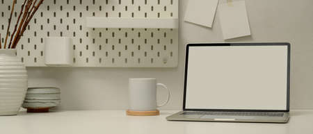 Close up view of modern worktable with copy space, mock up laptop, coffee cup and decorations in...
