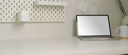 Cropped shot of modern worktable with copy space, mock up laptop, coffee cup and decorations in home...