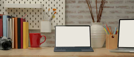 Close up view of study tale with mock up tablet, laptop, books, camera, stationery, supplies and...