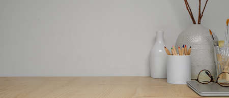 Close up view of workspace with copy space, painting tools, supplies and decorations on wooden tableの写真素材