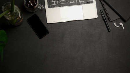 Overhead shot of office desk with copy space, laptop, smartphone, supplies and decorationsの写真素材