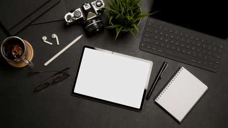 Top view of digital tablet with clipping path on dark office desk with office supplies and accessoriesの写真素材