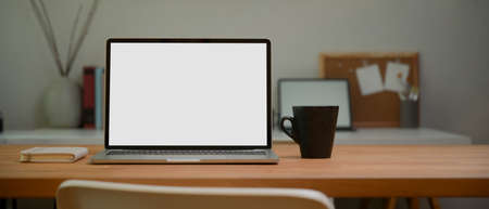 Close up view of portable workspace  laptop, mug and stationery on wooden table,  .の写真素材
