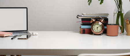Close up view of simple workspace  laptop, stationery, copy space, books and decorations on white...