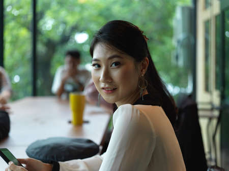 Portrait of businesswoman smiling and sitting in meeting room with her colleagues