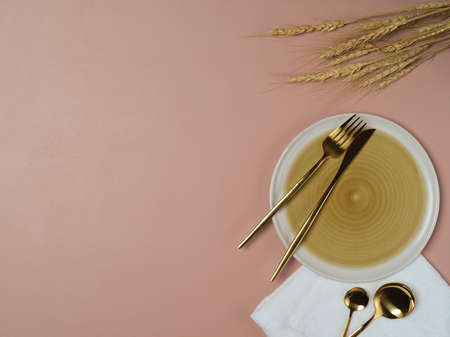 Top view of pink table with ceramic plate, cutlery, tablecloth and copy space in restaurantの写真素材