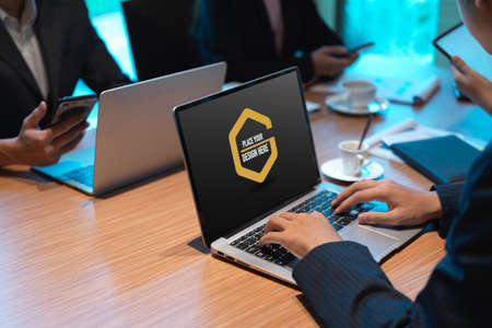 Side view of businesspeople working on mock up laptop while meeting in conference room