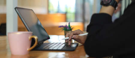 Side view of female freelancer working with digital tablet on worktable with coffee mug in co working spaceの写真素材