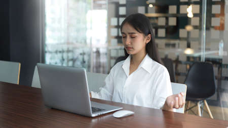 Side view of female office worker meditating before start her presentation in meeting room