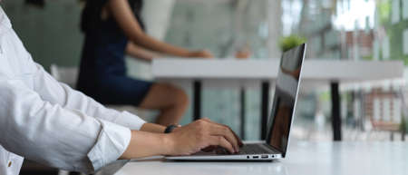 Cropped shot of young businesspeople group working with laptop computer in modern office room