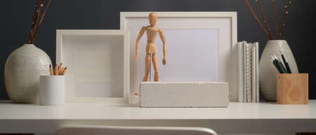 Close up view of worktable with mock cup frames, stationery, decorations and copy space in home...