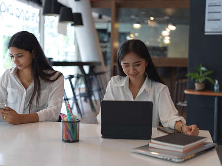 Young professional businesswomen working on their project together in modern office room