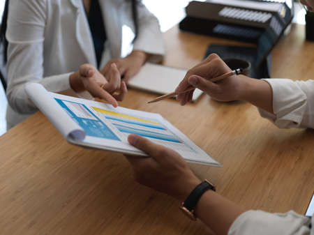 Cropped shot of young group of businesspeople discussing business plan togetherの写真素材