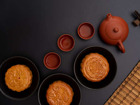 Top view of black table setting with traditional moon cakes, tea set and copy spaceの写真素材