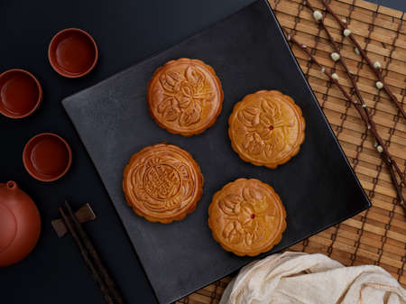 Top view of table setting with traditional moon cakes and tea set in moon festival. Chinese...