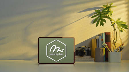 Close up view of mock up tablet on study table with copy space, camera and school elements in home officeの写真素材