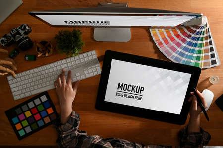 Top view of female graphic designer working with mock up drawing tablet, camper and designer...