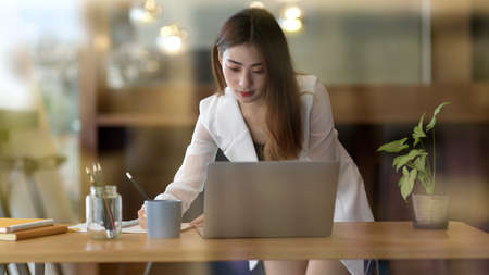 Close-up view of young professional businesswoman working the company project in office room