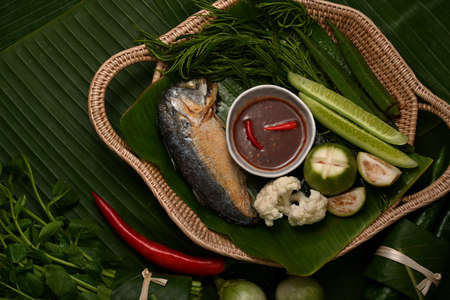 Top view of fried mackerel with shrimp paste sauce and vegetable set served on wicker trayの写真素材