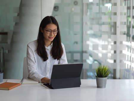 Cropped shot of female working with digital tablet in co working space
