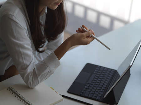 Cropped shot of young businesswoman working on her project with tablet in workspace